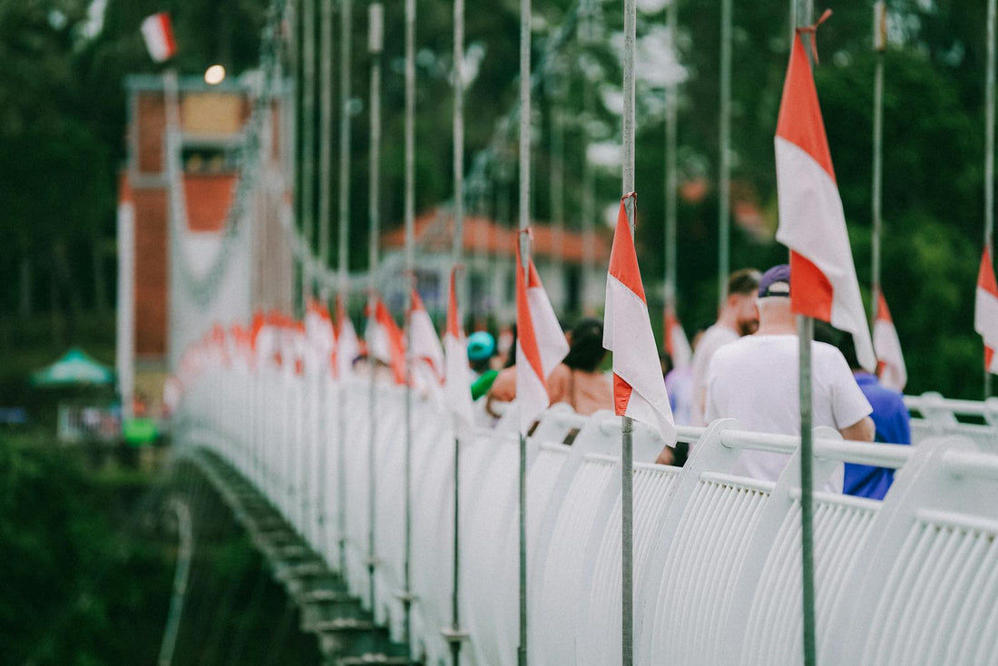 Tourists walk on a bridge with flags in Indonesia