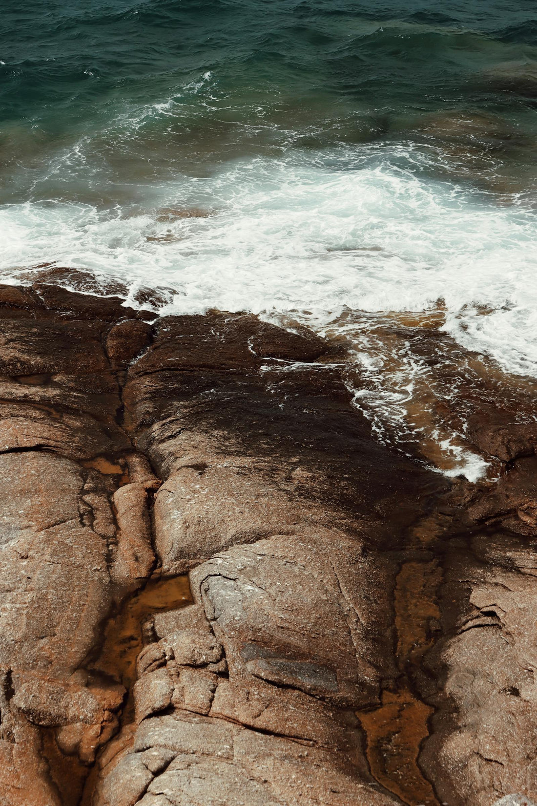 Rocks next to blue water in Naxos Greece